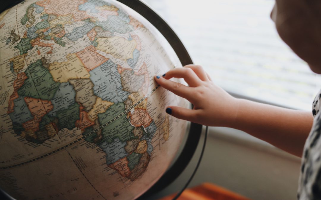 A Child Pointing at a Globe